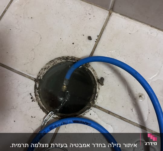 צינור כחול מחובר לניקוז ברצפה